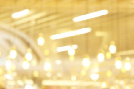 blurred light yellow gold bokeh Inside the mall luxury for background, bokeh golden abstract light shine background blurの写真素材