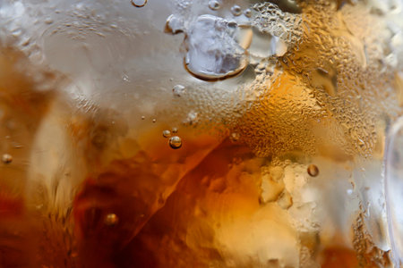 close-up beverage cola and cubes ice refreshing cool in glass, black cola soda in glass with ice...