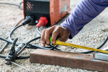 worker welder are holding tape measure in welding work, construction and metal work industrial...