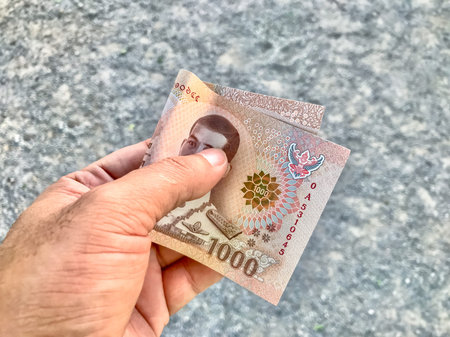 money banknote thai 1000 baht in hand are holding, savings money, giving or donate concept