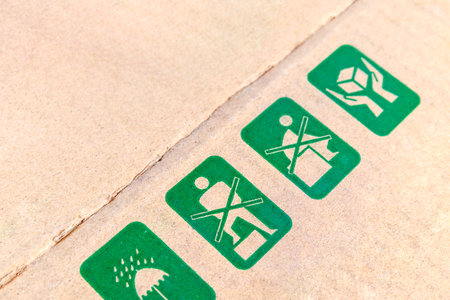 Shipping symbols on corrugated cardboard box, representing packaging, product handling, logistics, export import, and warehouse careの写真素材