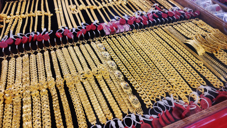 Gold jewelry, Rows of gold bracelet and necklaces displayed in jewelry store showcase, symbolizing wealth, investment, and luxury. Perfect for financial, economic, or gold market conceptsの写真素材