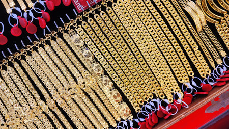 Gold jewelry, Rows of gold bracelet and necklaces displayed in jewelry store showcase, symbolizing wealth, investment, and luxury. Perfect for financial, economic, or gold market conceptsの写真素材