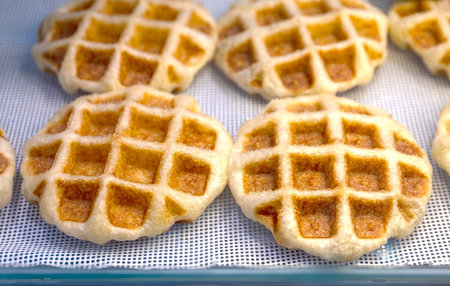 Waffle, Golden baked waffles on shelf, Waffle shop close-up, showcasing a crisp and appetizing...