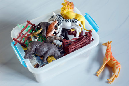 Plastic animal toys in storage box, Assorted plastic animal toys in a white storage box, including...