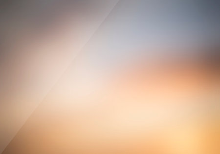 A subtle, blurred gradient background with warm beige, orange, and yellow tones is intersected by a soft diagonal line.の写真素材