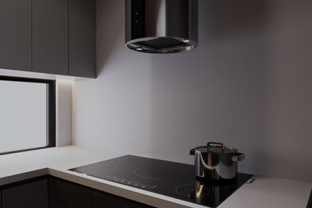 A kettle on the Electric stove on the kitchen counter with a kitchen hood in a modern kitchen.の写真素材