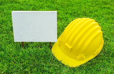 Empty White wood sign and Safety helmet on greenfieldの写真素材