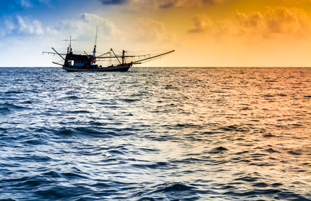 Fishing boat on the water and dramatic clouds at.の写真素材