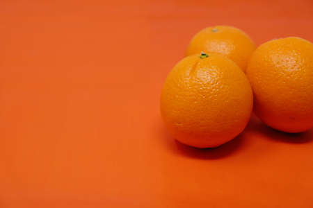 Citrus fresh orange fruit, group of three on orange color background for health concept.の写真素材
