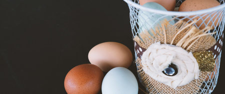 Chicken eggs from farm in rustic basket with black background.  Copy space on banner for food...