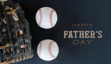 Sports fan Happy Father's Day graphic with baseballs and glove.  Black background with tan text for holiday.の写真素材