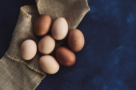 Group of brown eggs on burlap, rustic farm harvest with copy space