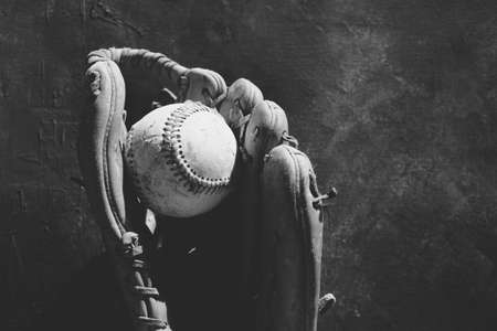 Used baseball in old glove close up, black and white.の写真素材
