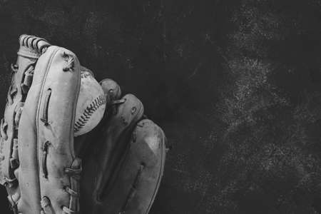 Used baseball glove with ball on background, copy space for sports concept in black and white.の写真素材