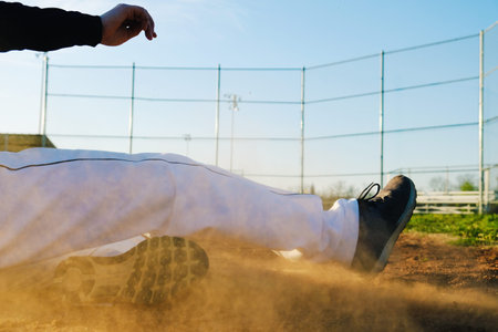 Action shot of sports athlete, shows baseball player slide on field