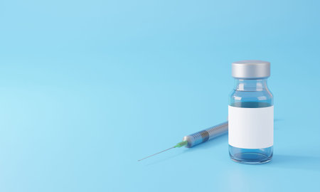 Blank white label on injection bottle glass vial with syringe against a blue background.Copy space...