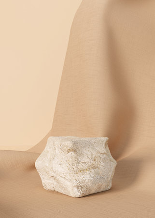 Minimalist still life with stone podium on beige background.