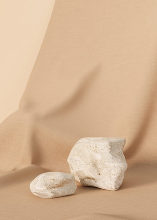Display Stones on beige fabric background. Minimalist composition.