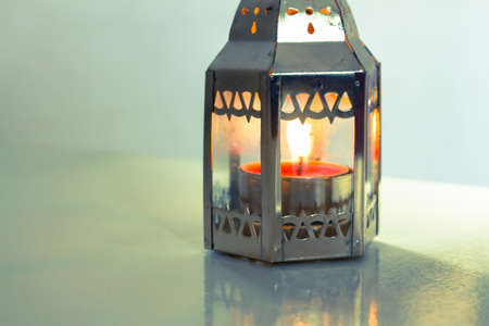 Gold candle on a colorful fabric table.の写真素材