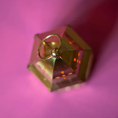Gold candle on a pink table.の写真素材
