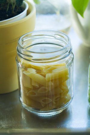 dry pasta in glass and pumpkin on wood .の写真素材