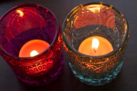 pink candle and light bule candle on a table .の写真素材