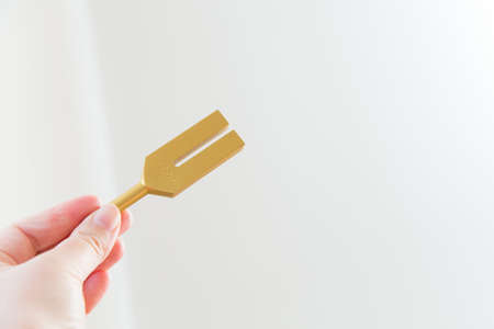 Hand holding a tuning fork and crystal stone  .の写真素材