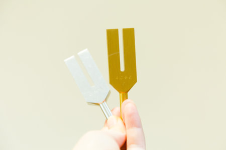 Male hand holding fork with yellow and white color on a light background