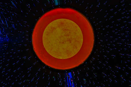 Water drops on CD The center hole of a yellow and orange background の写真素材
