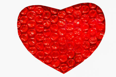 Red plastic heart with a white background の写真素材
