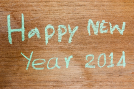 Happy New Year written with chalk colors on woodの写真素材