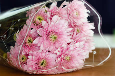 Beautiful pink flowers in plastic wrap on the table.の写真素材