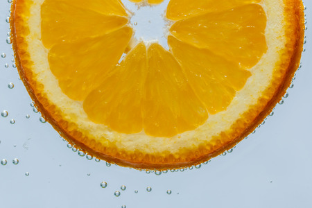 Close up of orange in water with bubbles の写真素材