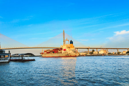 Bridge across big  river with  cargo shipsの写真素材