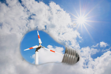 Ideas,Wind turbine in light bulb with a sky background with sun(concept natural source of energy).の写真素材
