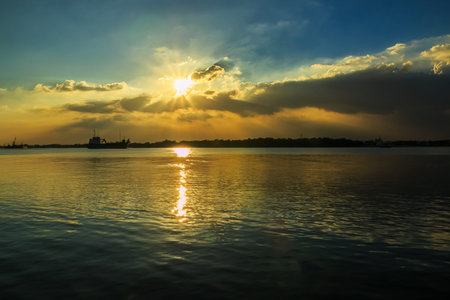 Sunset radiate above the clouds  reflection  in the river