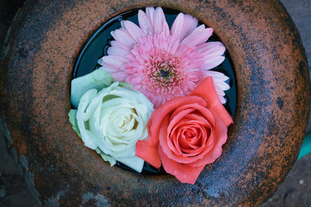 Roses and chrysanthemum floating in the  water jar