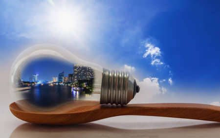 Concept  night lighting  of building in light bulb with sunlight backgroundの写真素材