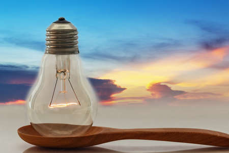 IdeasLight bulb that shines on the ladle with a sky eveningの写真素材