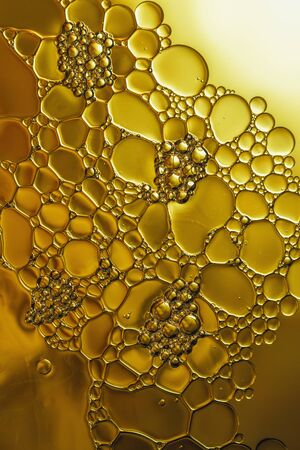 oil floating on water  with yellow backgroundの写真素材