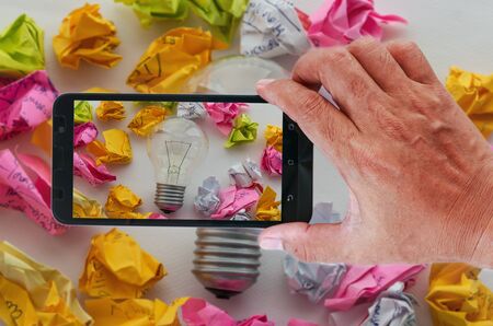 Smart phones photography a good idea concept with colorful crumpled paper and light bulbs.の写真素材