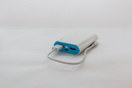White blue, battery power bank  charging mobile devices with white backgroundの写真素材