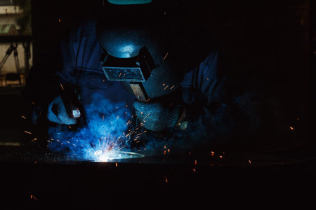 Welder of Metal Welding with sparks in industry steel weld