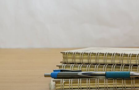 Pen and note book old recycle on wood backgroundの写真素材