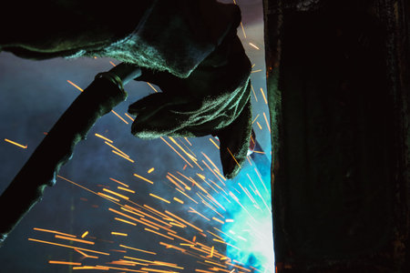 Welder of Metal Welding with sparks and smoke in manufacturingの写真素材