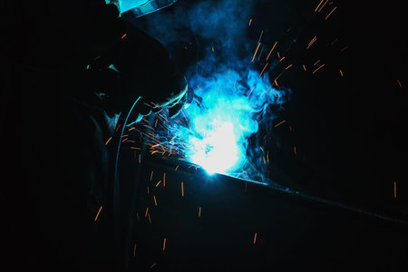 Welder of Metal Welding with sparks and smoke