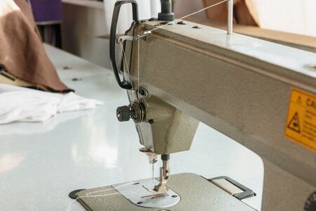 Industrial sewing machines close up , clothes at tailors shop.の写真素材