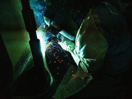 Welder of Metal Welding with sparks and smoke in manufacturing