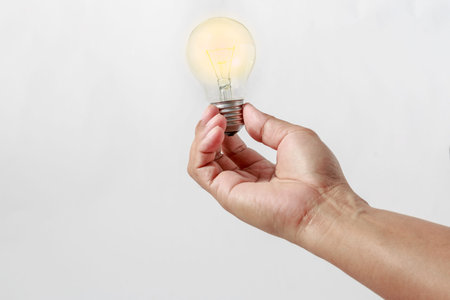 Man's hand holding an light  bulb  on white background with  concept for energy savings
